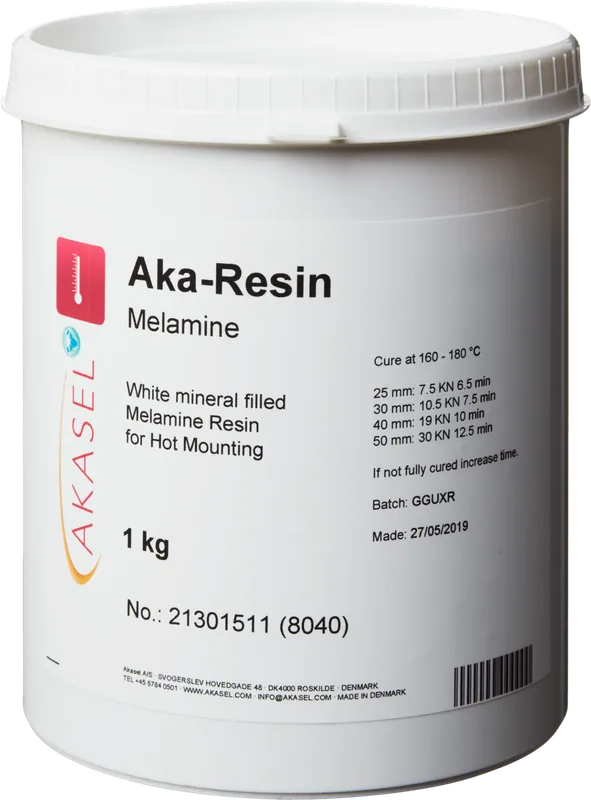 Akasel Aka-Resin Melamine: Vit plastbehållare fylld med vitt, mineralfyllt melaminharts för varminbäddning. Etiketten visar Akasel-logotypen och produktdetaljerna: "Aka-Resin Melamine," "White mineral-filled Melamine Resin for Hot Mounting," "1 kg." Tekniska specifikationer inkluderar härdningsvillkor: "Cure at 160 – 180 °C," diameter- och kraftvärden (t.ex. 25 mm: 10 kN, 4–5 min/2–3 min) samt instruktioner för att förlänga härdningstiden om den är ofullständig. Ytterligare information inkluderar ett batchnummer, tillverkningsdatum och varningssymboler. Speciellt utvecklad för metallografiska applikationer, idealisk för inbäddning av vita prover för exakt och stabil analys.