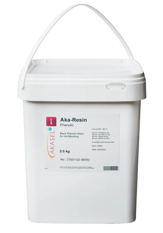 Akasel Aka-Resin Phenolic, svart fenolharts i en vit plastbehållare med bärhandtag. Etiketten visar produktnamnet "Aka-Resin Phenolic," "Black Phenolic Resin for Hot Mounting," vikt 2,5 kg, artikelnummer 21501122 (8055) och härdningsinstruktioner vid 160–180 °C. Ytterligare detaljer beskriver härdningstider och parametrar för prover med diametrar från 25 mm till 50 mm. Speciellt utvecklad för metallografiska applikationer för att förbereda prover för vidare analys.