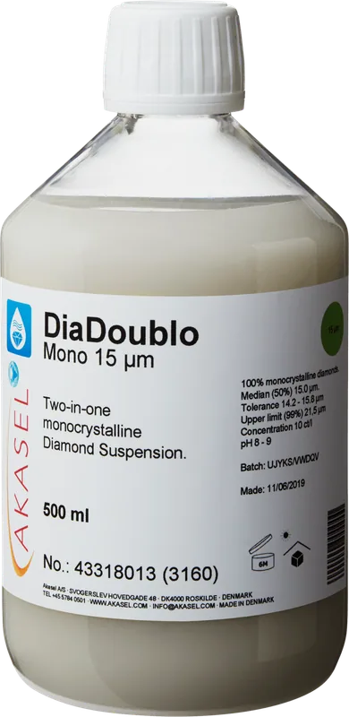 Akasel DiaDoublo Mono 15 µm: En 500 ml plastflaska med vit skruvkork, innehållande en ljus, mjölkvit monokristallin diamantsuspension, beskriven som en 2-i-1-diamantsuspension. Etiketten visar namnet “DiaDoublo Mono 15 µm” tillsammans med texten “Two-in-one monocrystalline Diamond Suspension.” Ytterligare synlig information inkluderar: “100% monocrystalline diamonds,” “Median (50%) 15 µm,” “Tolerance 14.2 – 15.8 µm,” “Upper limit (99%) 21.5 µm,” och “Concentration 10 ct/l.” Symboler på etiketten anger lagringsförhållanden, hållbarhet samt batch- och produktionsinformation.