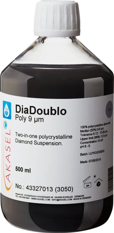 Akasel DiaDoublo Poly 9 µm: En 500 ml plastflaska med vit skruvkork, innehållande en svart polykrystallin diamantsuspension. Etiketten visar produktnamnet “DiaDoublo Poly 9 µm” tillsammans med texten “Two-in-one polycrystalline Diamond Suspension.” Ytterligare detaljer inkluderar: “100% polycrystalline diamonds,” “Median (50%) 9.6 µm,” “Tolerance 9.12 – 10.08 µm,” “Upper limit (99%) 12.9 µm,” och en koncentration på “10 ct/l.” Symboler på etiketten anger lagringsförhållanden och hållbarhet. Batchinformation och produktionsdatum är också tydligt synliga.